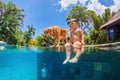 Little child swim with dog in blue swimming pool Royalty Free Stock Photo