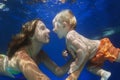 Little child swimming underwater in pool with mother Royalty Free Stock Photo