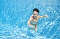 Little child swims underwater in swimming pool, happy active baby girl dives and has fun under water, kid fitness Royalty Free Stock Photo