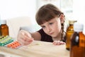 Little child taking pills from shelf. Danger of medicament intoxication