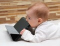 Little child tastes his tablet computer