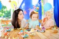 Little child and their mother celebrate birthday party with colorful decoration and cakes with colorful decoration and cake Royalty Free Stock Photo