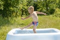 Little child toddler kid boy having fun playing splashing water in inflatable pool,private backyard during heat.Summer Royalty Free Stock Photo