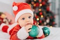 Little child under Christmas tree. baby boy in Santa Claus hat with gifts under Christmas tree with many gift boxes presents Royalty Free Stock Photo