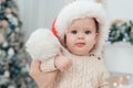 Little child under Christmas tree. baby boy in Santa Claus hat with gifts under Christmas tree with many gift boxes presents Royalty Free Stock Photo