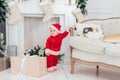 Little child under Christmas tree. baby boy in Santa Claus hat with gifts under Christmas tree with many gift boxes presents Royalty Free Stock Photo