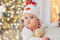 Little child under Christmas tree. baby boy in snowman hat with gifts under Christmas tree with many gift boxes presents Royalty Free Stock Photo