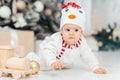 Little child under Christmas tree. baby boy in snowman hat with gifts under Christmas tree with many gift boxes presents Royalty Free Stock Photo