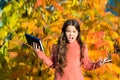 Little child unhappy learning in autumn park. Kid study with book. Keep studying. Small girl read book on autumn day