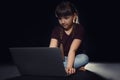 Little child using laptop on dark background Royalty Free Stock Photo