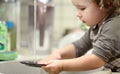 Little child is washing dishes in kitchen