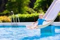 Little child on water slide in swimming pool