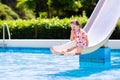 Little child on water slide in swimming pool