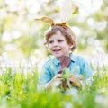 Little child wearing Easter bunny ears and eating chocolate at s Royalty Free Stock Photo