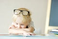 Little child wearing glasses is having fun with a book. Cute boy is watching pictures and learning letters. Preparation for school Royalty Free Stock Photo