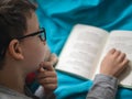 Little child, 8 years old boy reading a book at home with his toy teddy bear Royalty Free Stock Photo