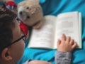 Little child, 8 years old boy reading a book at home with his toy teddy bear Royalty Free Stock Photo