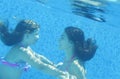 Little child and young woman underwater in the swimming pool Royalty Free Stock Photo