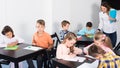 Little children with attentive teacher drawing in classroom