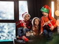 Little children with Christmas gifts near window. Presents from Santa Claus Royalty Free Stock Photo