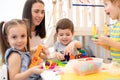 Little children engaged in playdough modeling at daycare