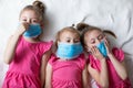 Little children girls in medical masks. Global quarantine at home. Pandemic protection
