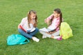 Little children girls read books sit on grass, knowledge day concept