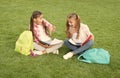 Little children girls read books sit on grass, knowledge day concept