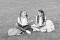 Little children girls read books sit on grass, summer school concept Royalty Free Stock Photo