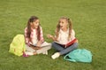 Little children girls read books sit on grass, summer school concept Royalty Free Stock Photo