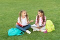 Little children girls read books sit on grass, summer school concept