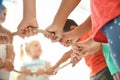 Little children holding rope on light background, focus on hands