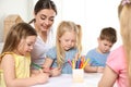 Little children with kindergarten teacher drawing at table. Learning and playing Royalty Free Stock Photo