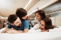 Little children lie on the backs of young happy parents in a mattress store. Royalty Free Stock Photo