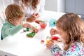 Little children with a nanny to prepare for Christmas. They sit at the table in the room