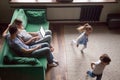 Little children playing catch-up while parents using laptop Royalty Free Stock Photo