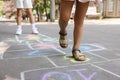 Little children playing hopscotch drawn with chalk on asphalt outdoors, closeup Royalty Free Stock Photo