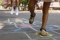 Little children playing hopscotch drawn with chalk on asphalt outdoors, closeup Royalty Free Stock Photo