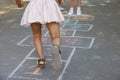 Little children playing hopscotch drawn with chalk on asphalt outdoors, closeup Royalty Free Stock Photo