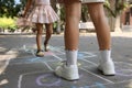 Little children playing hopscotch drawn with chalk on asphalt outdoors, closeup Royalty Free Stock Photo