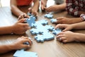 Little children playing with puzzle at table Royalty Free Stock Photo