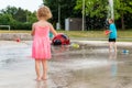 Little children playing at splash pad in the park. Playground with fountain for kids. Summer fun Royalty Free Stock Photo