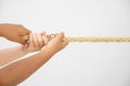 Little children pulling rope on light background, focus on hands. Royalty Free Stock Photo