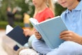 Little children reading books outdoors