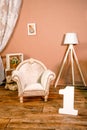 Little children's room interior in photo studio. Hall with tiny cute chair, vintage armchair, lamp. Photoshoot for