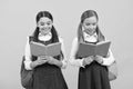 Little children in school uniforms read library books yellow background, reading Royalty Free Stock Photo