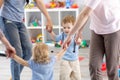 Little children and mothers roundelay in daycare Royalty Free Stock Photo