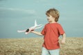 Little children with toy airplane in a field at sunset. Success and child leader concept. Boy dreams of becoming a pilot Royalty Free Stock Photo