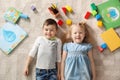 Little children with toys and books lying on carpet indoors. Playtime Royalty Free Stock Photo