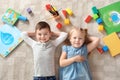 Little children with toys and books lying on carpet, top view. Playtime Royalty Free Stock Photo